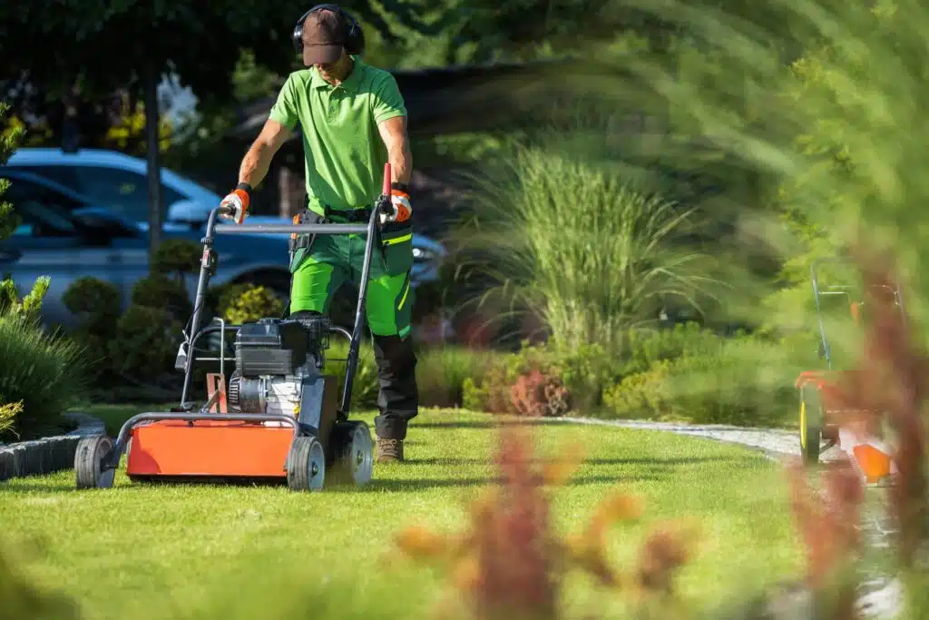 worker mowing lawn